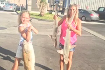 a little girl holding a fish