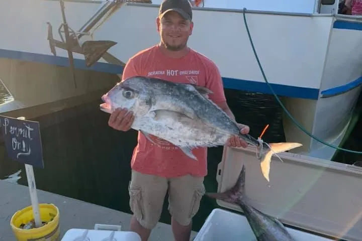 a person holding a fish on a boat