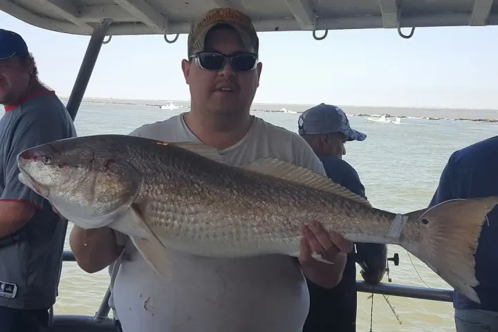 a man holding a fish on a boat