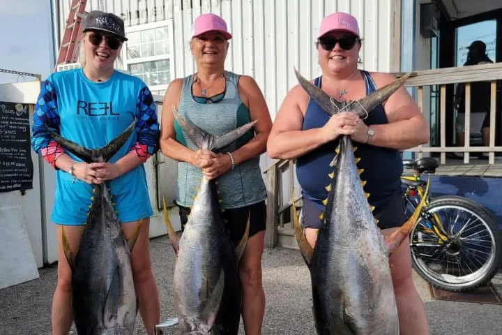 a group of people standing in front of a fish
