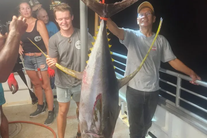 a group of people standing in front of a fish